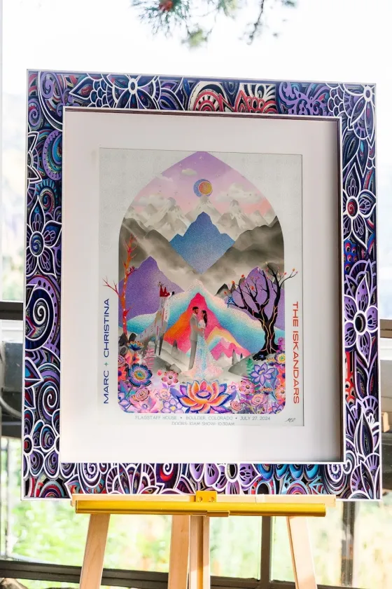 Framed gig-style wedding poster: the couple under a pastel mountain arch, “Marc + Christina, The Iskandars”
